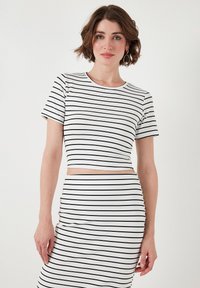 Crop top a righe bianco e nere con maniche corte e texture a coste, con scollatura rotonda e design aderente.