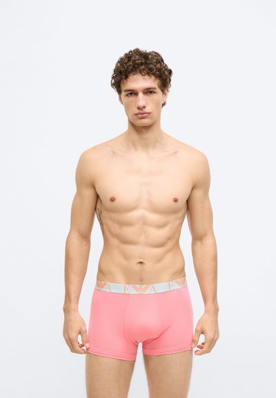 Cuecas boxer de algodão cor-de-rosa com cintura elástica azul-claro que apresenta o logótipo da marca. Projetadas com corte ajustado e textura suave.