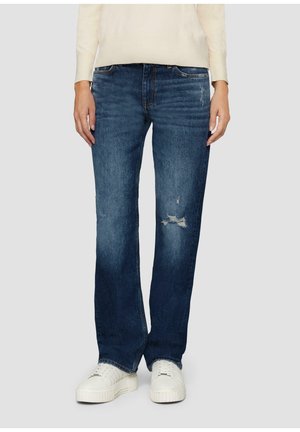 Dunkelblaue Denim-Jeans mit lockerer Passform, die an den Knien verwaschen sind und dezente Ausbleichungen aufweisen. Kombiniert mit weißen Sneakern.