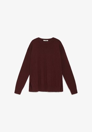Pull en maille bordeaux avec un col rond, des manches longues, des fentes sur les côtés, et des poignets et ourlet côtelés. Texture lisse avec une coupe décontractée.