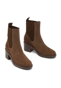 Botines de ante marrón con tacones de bloque apilados y paneles laterales elásticos con acanaladuras, diseñados para facilitar su puesta.