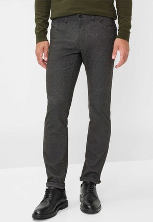 Dunkelgraue Hose aus strukturiertem Material, schlanker Schnitt mit umgeschlagenen Säumen, kombiniert mit schwarzen Dressschuhen.