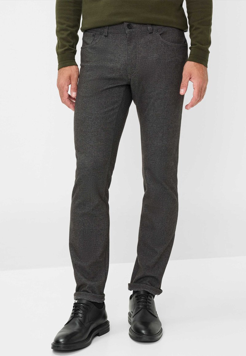 Donkergrijze broek van een gestructureerd materiaal, slim fit ontwerp met opgerolde boorden, gecombineerd met zwarte dresschoenen.