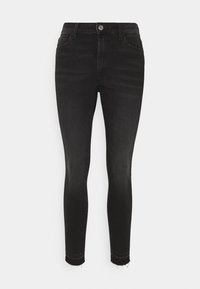 Jean skinny noir en denim. Possède une fermeture éclair et un bouton, cinq poches, et des ourlets effilochés. Fout des décolorations subtiles sur le tissu.