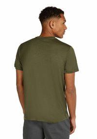 Olivgrön t-shirt med kort ärm, slät textur, rundad halsringning, avslappnad passform, med ett subtilt mönster. Bakifrån syns detaljer vid axelsömmen.