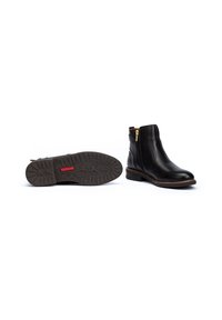 Bottines en cuir noir avec une fermeture éclair sur le côté, semelle texturée marron et couture minimaliste. Talon bas pour le confort et la stabilité.