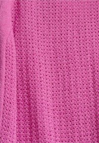 Tessuto di cotone di un vivace colore rosa con una trama a maglia aperta, caratterizzato da un motivo costante di piccoli fori sparsi. Morbido e traspirante.