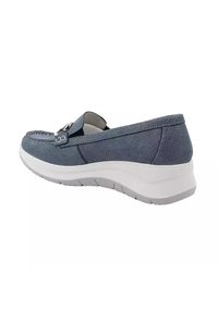 Scarpa slip-on blu con tomaia testurizzata, dettagli cuciti e suola bianca. Presenta un accento decorativo sulla parte anteriore.