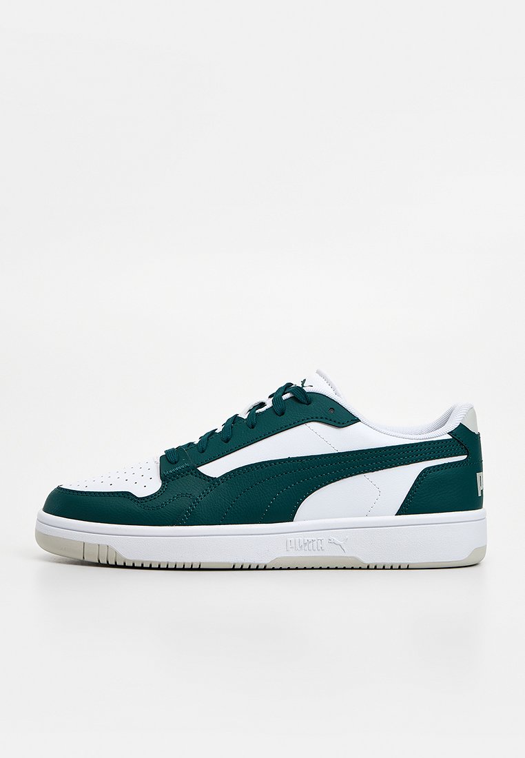 Zapatilla verde y blanca hecha de cuero texturizado y malla, con puntera perforada, cordones planos y logo sutil en el talón.