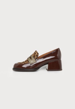 Brun patentlæder-sko med lav blokhæl, leopardmønstret frontpanel og tekstureret guldlås-detalje, vist på hvid baggrund.