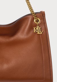 Rjava usnjena torba na rameno z teksturirano površino, z zlatim verižnim ročajem in RLL logotipom, pritrjenim na kovinsko obroček.