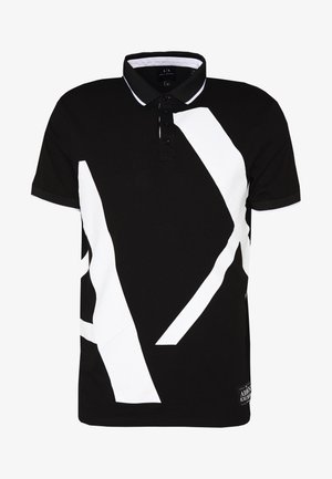 Schwarzes Polohemd mit kontrastierendem weißen geometrischen Design, Drei-Knopf-Leiste und schwarzem geripptem Kragen. Der Stoff wirkt glatt und weich.