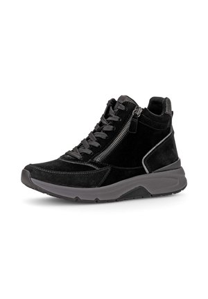 Zwarte suède sneaker met zwarte veters, een zijrits en een dikke donkergrijze rubberen zool, in profiel getoond op een witte achtergrond.