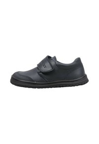 Chaussure noire à profil bas avec un bout arrondi, une semelle texturée et une large bande velcro sur le dessus pour un ajustement facile.