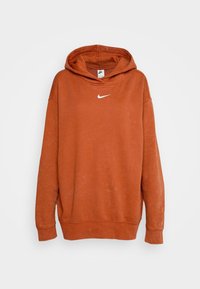 Oranžová bavlněná mikina s kapucí, přední kapsou a bílým logem Nike na hrudi. Má mírně vybledlou texturu.