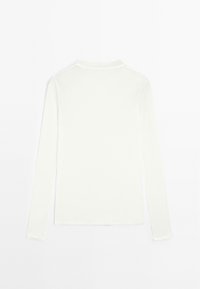 Camicia bianca a maniche lunghe con collo rotondo. Tessuto morbido e leggero con un design semplice e senza cuciture. Nessun motivo o dettagli visibili.