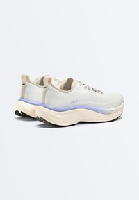 Chaussures de running beige clair avec semelle épaisse, accent lavande sur la semelle intermédiaire, empeigne en mesh et languettes de traction au talon, vues de côté arrière.