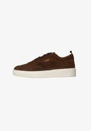 Braune Wildleder-Sneaker mit einer weißen Gummisohle. Merkmale sind eine runde Zehenform, ein Schnürdesign und eine kleine Schlaufe an der Ferse für ein einfaches An- und Ausziehen.