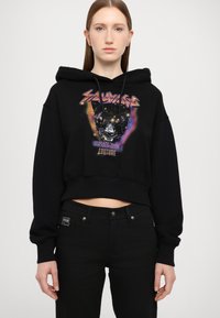 Hoodie corto nero con stampa grafica che presenta un pantera nera e accenti colorati. Tessuto morbido, maniche lunghe e cappuccio con cordino.