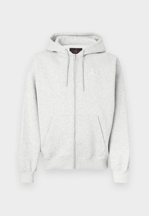 Sudadera gris con cremallera hecha de una tela suave, que presenta un bolsillo canguro frontal y un logo bordado en el pecho. Puños y dobladillo acanalados.