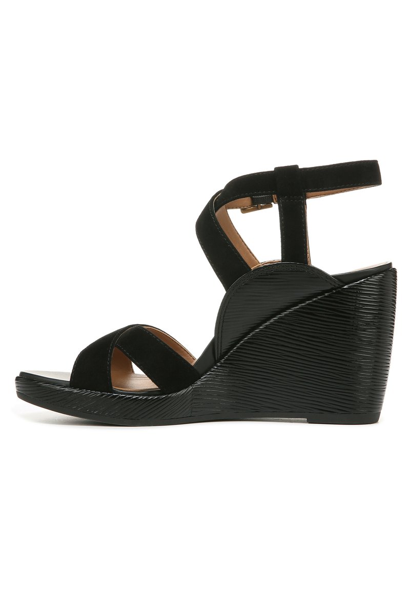 Zwarte wedgesandalen met een getextureerde wiggenhak, kruisschoenen en een enkelband met een gesp. Gemaakt van suede en synthetische materialen.