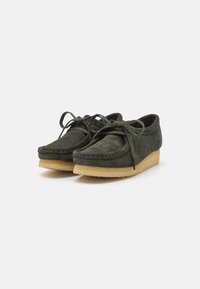 Dark green suede lace-up shoes with crepe rubber soles, displayed angled on a white background.