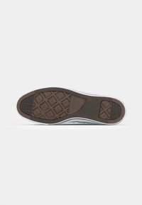Brown rubber sole with a geometric tread pattern, white accent along the edge, and a slightly textured surface.