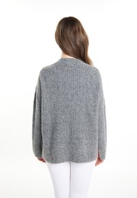 Maglione grigio lavorato a maglia con una vestibilità ampia, caratterizzato da una trama a coste e un collo arrotondato. Le maniche sono lunghe e leggermente cadenti sulle spalle.