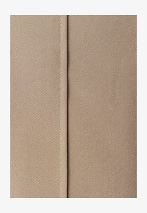 Beżowy materiał o gładkiej teksturze, z centralnym szwem podkreślonym kontrastowym stębnowaniem. Zbliżenie na powierzchnię materiału.