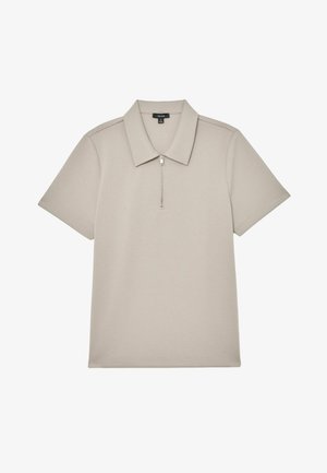 Rövid ujjú galléros póló világos bézs anyagból, cipzáras gallérral, sima textúrával és mintát nélkülöző minimalista dizájnnal.