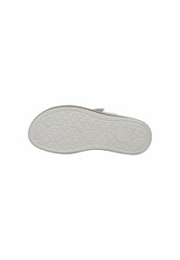 White rubber sole with a textured honeycomb pattern, featuring a raised logo and a beige edge. Soft, flexible design for comfort.