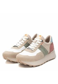 Zapatillas beige y blancas con acentos verdes y rosas. Parte superior de malla, cuello acolchado y suela de goma. Diseño con cordones y detalles de logo.
