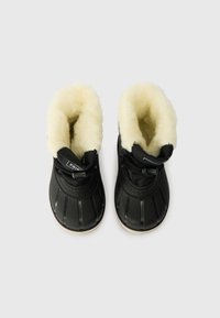 Fekete vízálló csizmák, texturált gumiból készült külső résszel, műszőrme béléssel, elasztikus fűzővel és mintás gumitalppal.