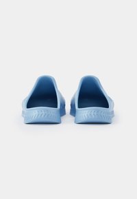 Sapatos azuis de borracha, tipo slip-on, com parte traseira arredondada, solas texturizadas e sem salto. Apresentam um design aberto para maior respirabilidade.
