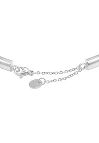 Bracciale in metallo argentato con design cilindrico, chiusura a hardware e una fine catena con un piccolo disco etichettato "S.steel."