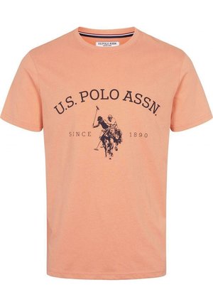 Pfirsichfarbenes T-Shirt mit kurzen Ärmeln, mit dem Text U.S. Polo Assn. und einer Grafik eines Polospielers auf einem Pferd in Schwarz auf der Vorderseite.