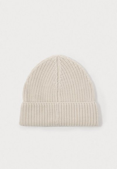 Knit beanie in light beige, featuring ribbed texture, a folded cuff, and a rounded top with vertical seam detail.