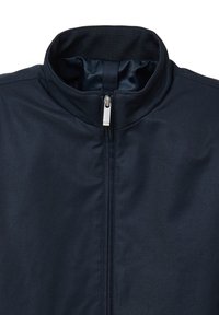 Giacca blu navy con zip alta, realizzata in tessuto liscio. Presenta una cerniera argentata e un rivestimento interno testurizzato al colletto.