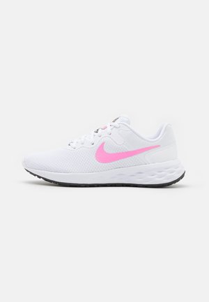 Zapatilla deportiva blanca con el logo rosa de Nike, parte superior de malla, suela acolchada y suela exterior negra, mostrada de lado sobre un fondo liso.