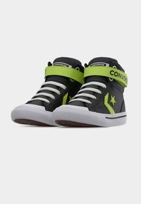 Μαύρα ψηλοτά αθλητικά παπούτσια με λευκά κορδόνια και λουρί σε νέον πράσινο χρώμα με αστέρια, λευκές λαστιχένιες σόλες, από μπροστινή πλάγια όψη.