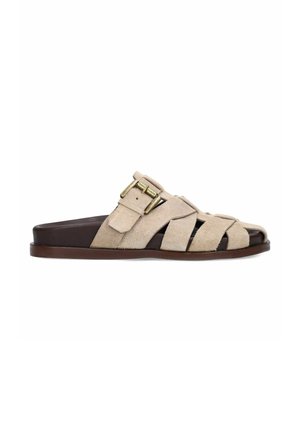 Beige suede slide sandal with open toe, dark brown sole, and adjustable gold-tone buckle strap across the top.