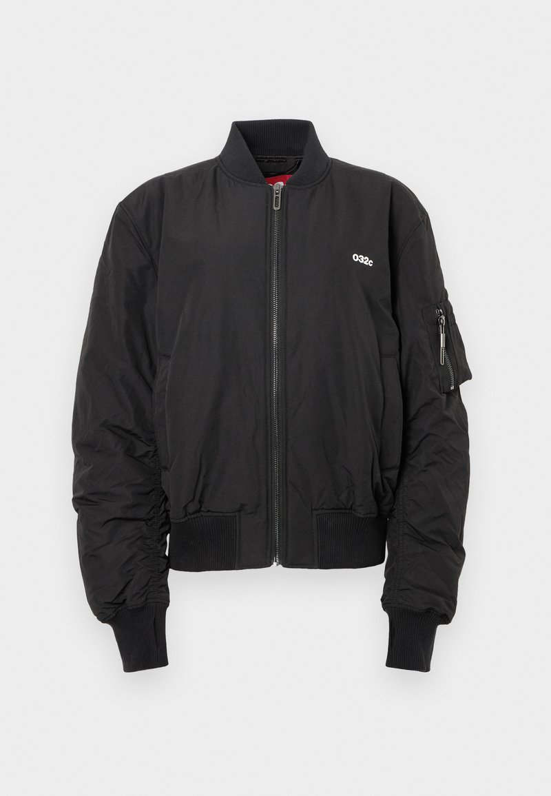Veste aviateur noire avec fermeture éclair à l'avant, poignets et taille côtelés. Présente un logo sur la poitrine et une poche zippée sur la manche gauche.