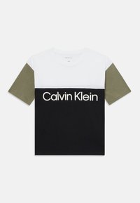T-shirt color-blocké avec des sections blanches, vert olive et noires. L'avant affiche le logo "Calvin Klein" en lettres blanches sur un tissu noir.