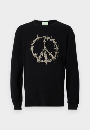 Čierna rebrovaná mikina s dlhými rukávmi, na ktorej je béžový vyšívaný symbol pokoja obkolesený ostnatým drôtom. Má okrúhly výstrih a mäkkú textúru.