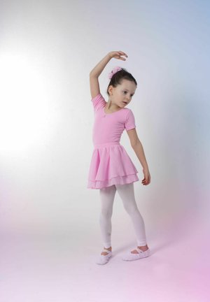 Helles rosa Ballettkleid mit kurzen Ärmeln und geschichtetem Rock, kombiniert mit weißen Strumpfhosen und weichen Ballettschläppchen, sowie einem Haaraccessoire.