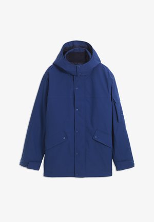 Veste à capuche bleu marine avec boutons-pression à l'avant, deux poches à rabat inclinées, bracelets de poignet ajustables et une poche sur la partie supérieure gauche de la manche.