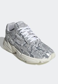 Grå och vita sneakers med ormskinnsstruktur, utrustade med en dämpad sula, snörningsdesign och en vadderad krage. Logotypdetalj på sidan.