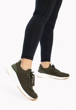 Baskets de sport vert olive avec tige en maille, accents texturés et semelle extérieure blanche. Elles disposent de lacets assortis et d'un collier rembourré.