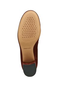 Suela de zapato de ante marrón con goma texturizada en la parte inferior, presentando patrones estriados y punteados para mayor tracción. Logotipo de la marca visible.