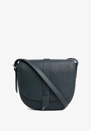 Tume rohelise nahast ristseljakott, millel on klapi sulgemine, reguleeritav rihm ja lihtne, sile tekstuur. Omab minimalistlikku disaini.